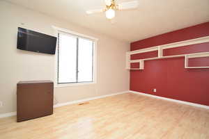 Empty room featuring light wood finished floors and a ceiling fan