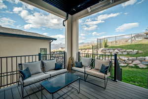 Main level deck featuring an outdoor living space, a mountain view, and a yard