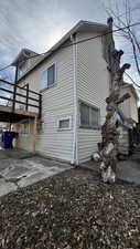 View of side of property featuring a chimney, a wooden deck, and a patio area