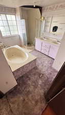 Bathroom with a bath, double vanity, a stall shower, and carpet