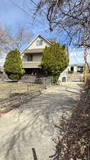 View of front facade with a shingled roof and driveway