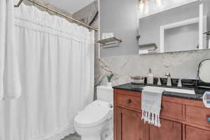 Bathroom with vanity, backsplash, and a shower with curtain