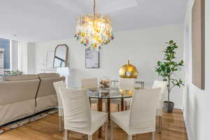 Dining room with light wood-type flooring and a chandelier
