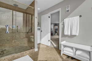 Full bathroom with a shower stall, light tile patterned floors, and light carpet