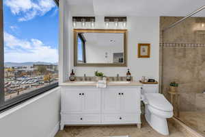 Full bathroom with double vanity, a stall shower, and a mountain view