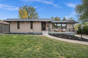 View of front of home with brick siding, a standing seam roof, and a metal roof