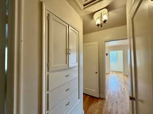Hallway with light wood-style flooring and baseboards