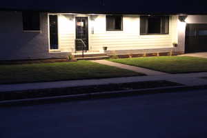 View of front of home with brick siding, a front lawn, and a garage