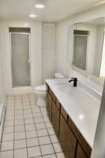 Bathroom featuring vanity, light tile patterned flooring, recessed lighting, a baseboard radiator, and a shower stall