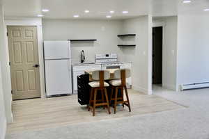 Kitchen with open shelves, a kitchen breakfast bar, recessed lighting, white appliances, and light countertops