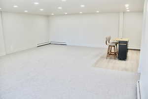 Basement featuring recessed lighting, light carpet, and baseboard heating