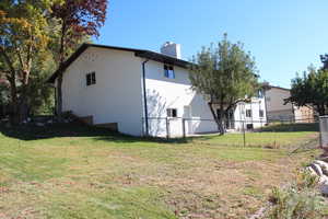 View of property exterior featuring a chimney and brick siding