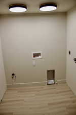 Washroom with electric dryer hookup, gas dryer hookup, light wood-style flooring, and hookup for a washing machine
