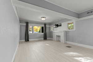 Unfurnished living room with light wood-style floors and a brick fireplace