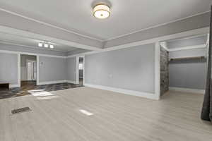 Unfurnished living room featuring light wood-style floors and baseboards