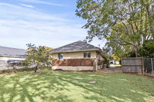 Back of property with a chimney and a shingled roof