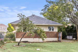 View of side of property with roof with shingles