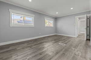 Unfurnished bedroom with ornamental molding, light wood finished floors, and recessed lighting