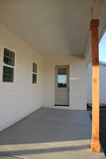 View of exterior entry with a patio area