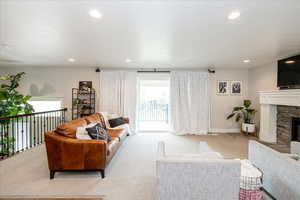 Carpeted living room with a fireplace and recessed lighting