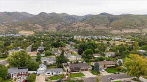 Aerial view of property and surrounding area with nearby suburban area and mountains
