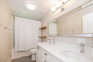 Full bathroom featuring double vanity and shower / bathtub combination with curtain