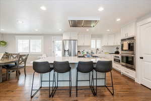 Kitchen with a kitchen island, white cabinetry, appliances with stainless steel finishes, recessed lighting, and a textured ceiling