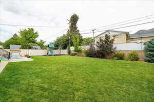 Fenced backyard with a playground and a patio area