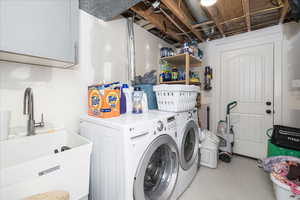 Laundry room with independent washer and dryer, tile patterned flooring, and cabinet space