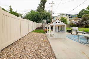 Fenced backyard featuring a playground and a deck