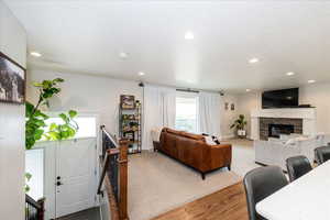 Living room featuring wood finished floors, a fireplace, recessed lighting, and a textured ceiling
