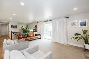 Carpeted living room with baseboards and recessed lighting