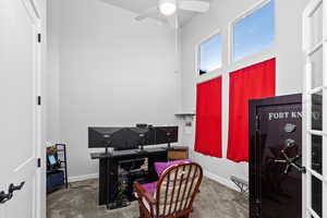 Carpeted office with a high ceiling and ceiling fan