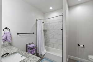 Full bathroom featuring shower / bath combination with curtain, vanity, and recessed lighting