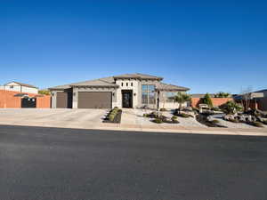 Prairie-style house with driveway, an attached garage, stone siding, and a residential view