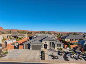 Prairie-style house featuring a residential view, driveway, an attached garage, stone siding, and a mountain view