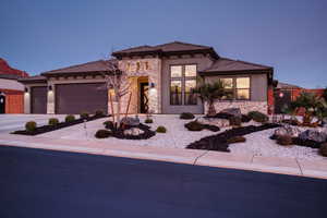 Prairie-style home featuring stone siding, a tile roof, and an attached garage