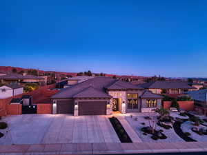 View of front of home featuring stone siding, an attached garage, driveway, a residential view, and stucco siding