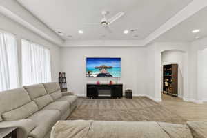 Living area featuring ceiling fan, recessed lighting, and arched walkways