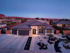 Mediterranean / spanish-style house featuring stone siding, driveway, a residential view, a garage, and stucco siding