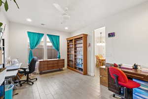 Office space with wood finish floors, ceiling fan, a chandelier, and recessed lighting