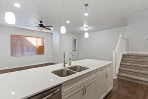 Kitchen with dark wood-type flooring, pendant lighting, white cabinetry, dishwasher, and ceiling fan