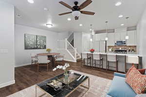 Living area with stairs, ceiling fan, dark wood-style floors, and recessed lighting