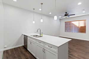 Kitchen with a peninsula, white cabinetry, hanging light fixtures, recessed lighting, and dark wood finished floors