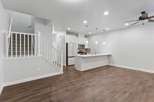 Unfurnished living room featuring stairway, dark wood-type flooring, recessed lighting, and ceiling fan