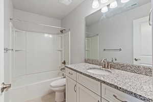 Bathroom with vanity, bathing tub / shower combination, and light tile patterned flooring