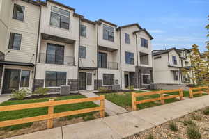 View of front of property with stone siding, a balcony, board and batten siding, and a residential view
