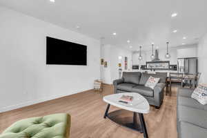 Living area featuring light wood-style floors and recessed lighting