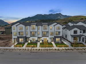 View of front of house featuring board and batten siding, stone siding, a fenced front yard, and a mountain view