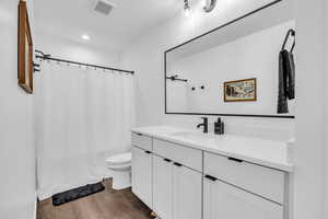 Full bath with dark wood finished floors, vanity, a shower with shower curtain, and recessed lighting